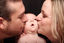 Родители целуют малыша