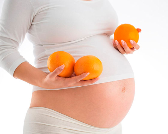 Беременная с апельсинами